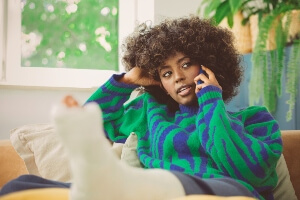 young black woman in cast talking on her mobile