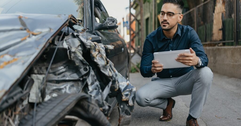 A man examining car damage.